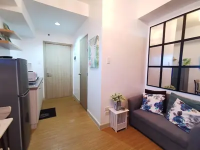 a living room with a couch and a kitchen at Nathan's Pad @ Grace residences Nr. BGC in Manila