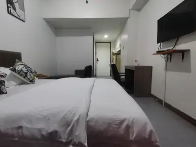 a bedroom with a white bed and a television at Accommodation Service in Manila