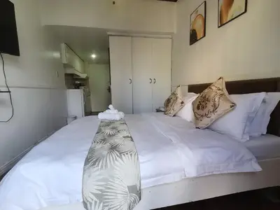 a bedroom with a large bed with white sheets and pillows at Accommodation Service in Manila