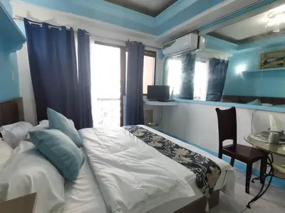 a bedroom with a bed and a table and a window at Accommodation Service in Manila