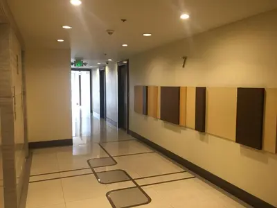 a hallway in a building with paintings on the wall at Cozy Condo Near NAIA with WIFI, Pool and Balcony in Manila