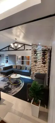 a living room with a couch and a table at Lax Uno 2 bedroom home with Parking, Wi-Fi, NetFlix and Airconditioned Rooms and Shower Heater in Antipolo