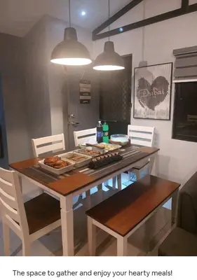 a dining room table and chairs with food on it at Lax Uno 2 bedroom home with Parking, Wi-Fi, NetFlix and Airconditioned Rooms and Shower Heater in Antipolo