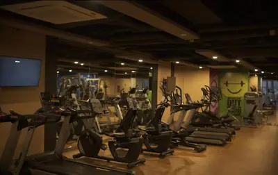 a gym with a bunch of cardio equipment in a room at Luxurious 2 Bedroom Family Suite plus Maid Rm in Eastwood City in Manila