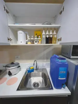 a kitchen counter with a sink and a kitchen appliance at Apartment Condo in Air Residences Makati wifi Netflix Disney, pool & mall in Manila