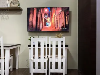 two white chairs in a room with a tv on the wall at Apartment Condo in Air Residences Makati wifi Netflix Disney, pool & mall in Manila