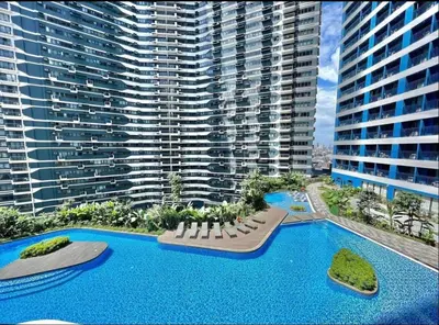 an aerial view of a large building with a swimming pool at Apartment Condo in Air Residences Makati wifi Netflix Disney, pool & mall in Manila