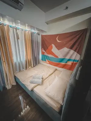 a bed in a room with a painting on the wall at Apartment Condo in Air Residences Makati wifi Netflix Disney, pool & mall in Manila