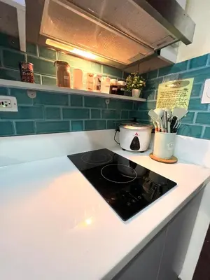 a kitchen counter top with a stove top oven at Apartment in Air Residences, Makati with wifi, Netflix, pool, mall and more in Manila