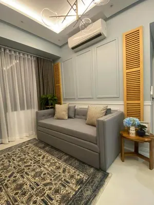 a living room with a gray couch and a table at The Florence at McKinley Hill in Manila