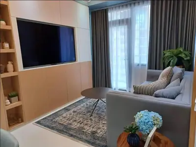 a living room with a couch and a television at The Florence at McKinley Hill in Manila