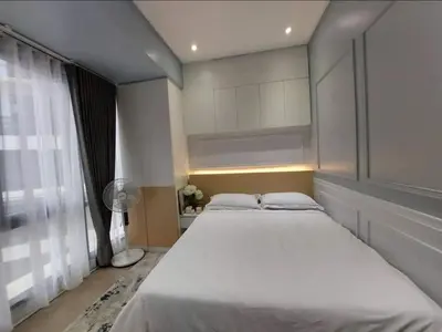 a bedroom with a large bed and a window at The Florence at McKinley Hill in Manila