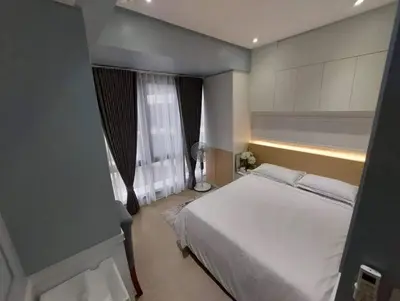 a bedroom with a white bed and a window at The Florence at McKinley Hill in Manila