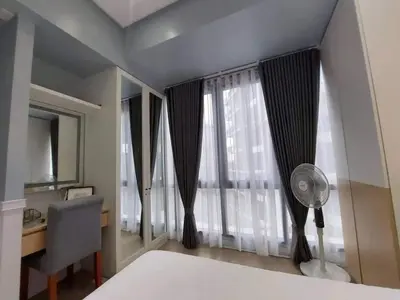 a bedroom with a bed and a desk and a window at The Florence at McKinley Hill in Manila