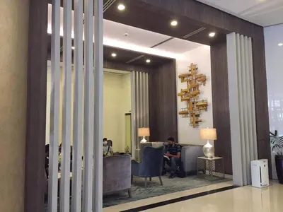 a person sitting in a chair in a lobby at The Florence at McKinley Hill in Manila