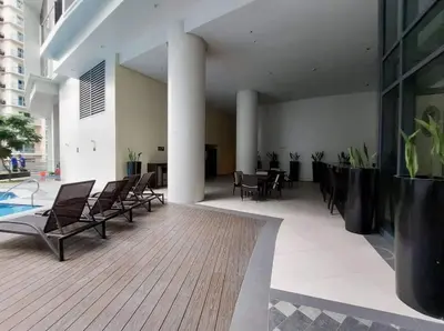 a lobby with chairs and a pool in a building at The Florence at McKinley Hill in Manila
