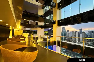 a balcony with chairs and a view of a city at The Gramercy Residences in Manila