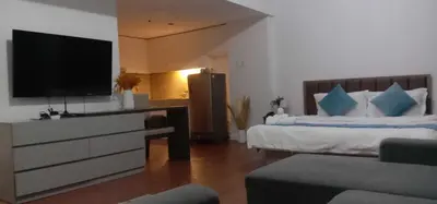 a bedroom with a tv and a bed with a couch at Accommodation services in Manila