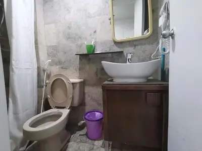 a bathroom with a sink and a toilet and a mirror at Accommodation services in Manila