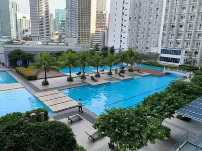 a man standing in front of a large pool in a city at BCP Homes in Manila