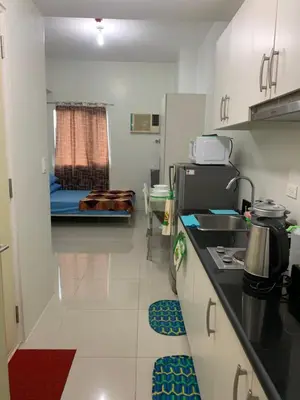 a kitchen with a sink and a room with a bed at BCP Homes in Manila
