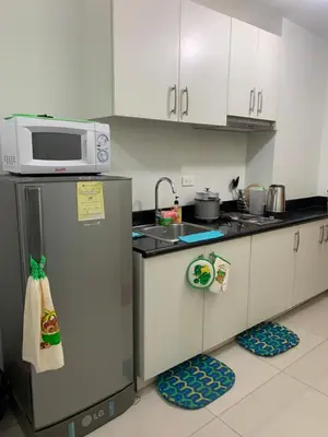 a kitchen with a microwave on top of a refrigerator at BCP Homes in Manila