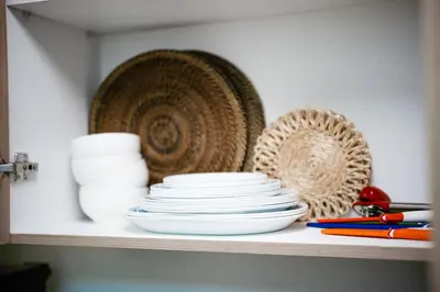 a shelf with plates and other items on it at Tatet Staycation Short Walk to SM MOA in Manila