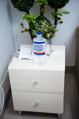 a bottle of water sitting on top of a white dresser at Tatet Staycation Short Walk to SM MOA in Manila