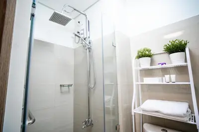 a shower with a glass door in a bathroom at Tatet Staycation Short Walk to SM MOA in Manila
