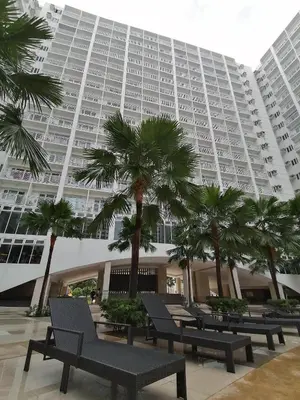 a large building with benches and palm trees in front of it at Shore Residence condotel,Pasay city Philippines in Manila