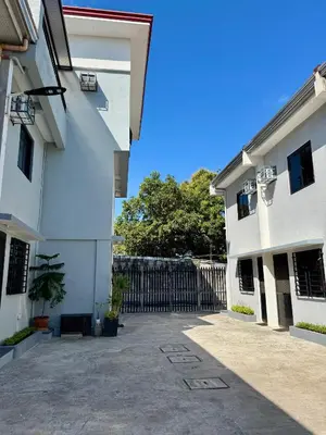 an alley between two white buildings with a gate at Sebastian’s Crib F in Dasmariñas