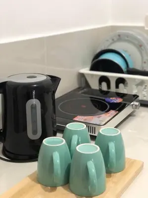 a group of green cups on a counter next to a toaster at Sebastian’s Crib F in Dasmariñas