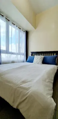 a bedroom with a large white bed with a window at Sea-Sky Perch Suite in Manila