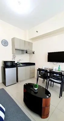 a large living room with a table and a kitchen at Sea-Sky Perch Suite in Manila