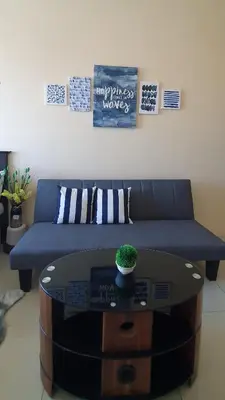 a living room with a blue couch and a table at Sea-Sky Perch Suite in Manila
