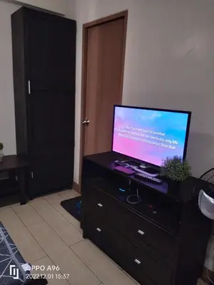 a flat screen tv sitting on a dresser in a room at RQUI CONDOTEL INFRONT OF NAIA TERMINAL 3 in Manila
