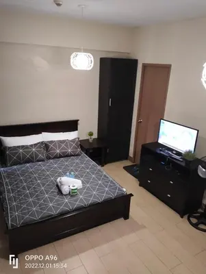 a bedroom with a bed and a flat screen tv at RQUI CONDOTEL INFRONT OF NAIA TERMINAL 3 in Manila