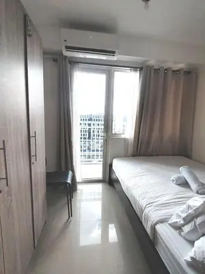 a bedroom with a bed and a large window at Shore One Condotel At Mall of Asia, Philippines in Manila