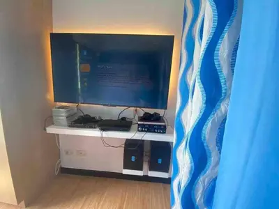 a computer monitor sitting on top of a desk at Cozy 1BR cityview with Balcony and near Airport in Manila