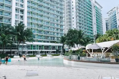 a swimming pool in front of some tall buildings at Cozy 1BR cityview with Balcony and near Airport in Manila