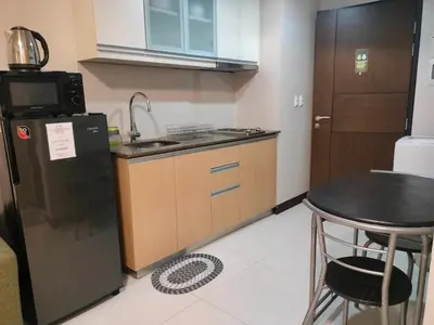 a small kitchen with a sink and a refrigerator at 101 Newport Boulevard near NAIA Terminal 3 in Manila