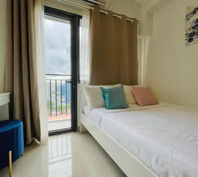 a bedroom with a bed and a large window at Sakan 5-Star Quality Condotel in Manila