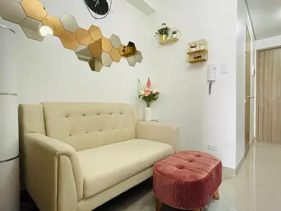 a living room with a couch and a stool at Sakan 5-Star Quality Condotel in Manila