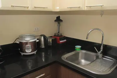 a kitchen counter with a sink and a mixer at A2J Luxury Studio Near Venice Mall BGC Taguig in Manila