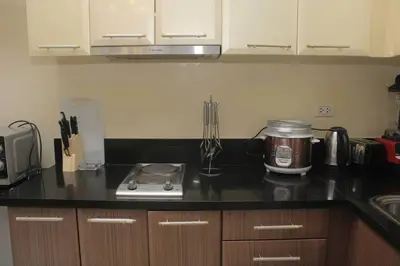a kitchen with a stove and a counter top at A2J Luxury Studio Near Venice Mall BGC Taguig in Manila