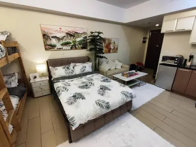 a bedroom with a bed and a living room at A2J Luxury Studio Near Venice Mall BGC Taguig in Manila