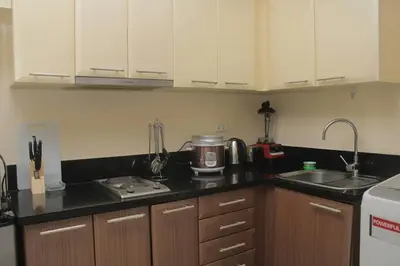 a kitchen with white cabinets and a counter top at A2J Luxury Studio Near Venice Mall BGC Taguig in Manila