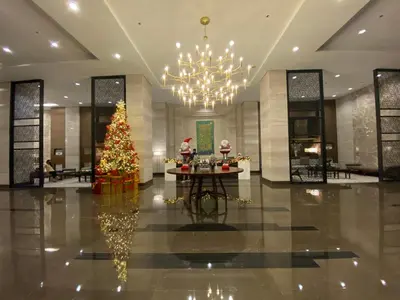 a lobby with a christmas tree and a chandelier at Le 10 The Radiance Manila Bay in Manila