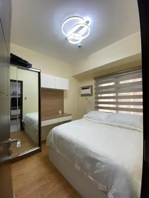 a bedroom with a white bed and a mirror at Le 10 The Radiance Manila Bay in Manila