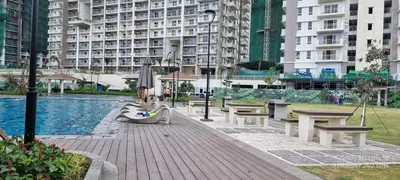a group of benches next to a pool with buildings at A cozy 2 bedroom condo in Metro in Manila